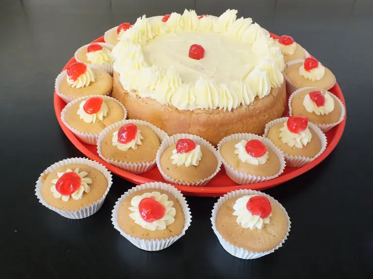 A freshly made celebration cake and decorated fairy cakes
